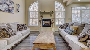 A spacious living room with two sofas, a wooden coffee table, and a fireplace. - Pocono Retreat -1 Mile to Lake and Skiing (Lake Harmony)
