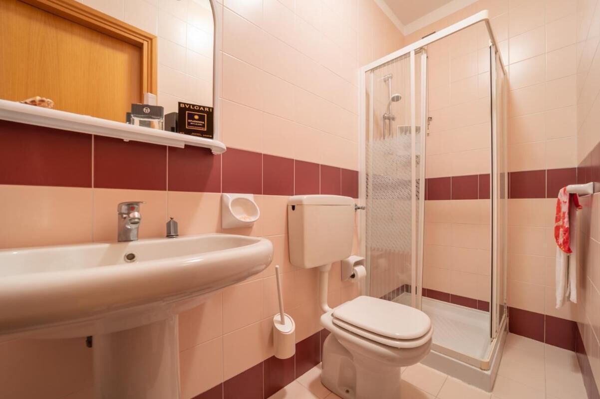 Een badkamer met een wastafel, toilet en douchecabine.