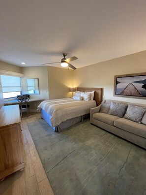 Relax in this inviting bedroom with a large bed, sofa, and desk, perfect for work or unwinding.