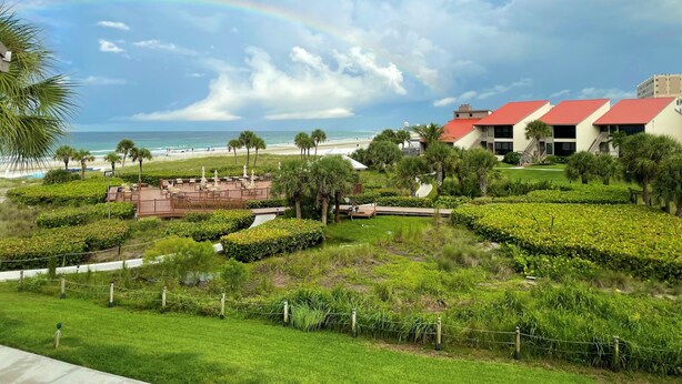 A resort with a beach view, a red-roofed building, and a well-maintained garden. - Cresent Beach Gulf view 2Bd/2Ba Condo (Sarasota)