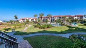 A hotel with multiple buildings, a swimming pool, and palm trees. - Spectacular view on Crescent beach (Sarasota)