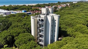 Un bâtiment moderne à plusieurs étages, entouré d’une végétation luxuriante.