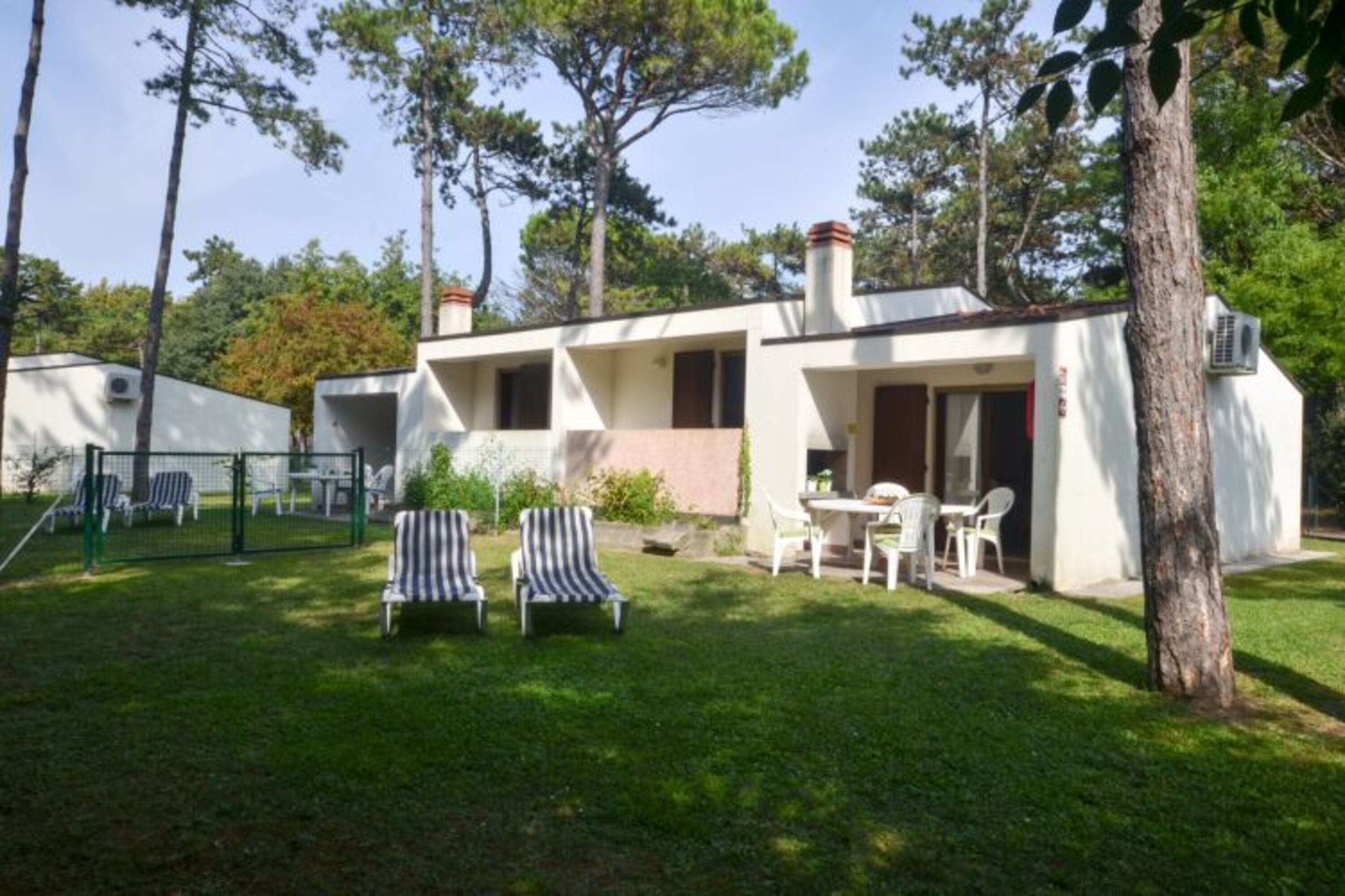 A single-story building with a patio area, outdoor seating, and a small garden.
