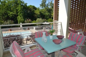 Outdoor dining - Charming apartment with balcony and shared pool (Bibione Pineda)