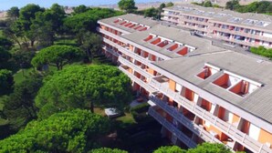 Un hôtel à plusieurs étages, doté de balcons et offrant une vue sur la mer.