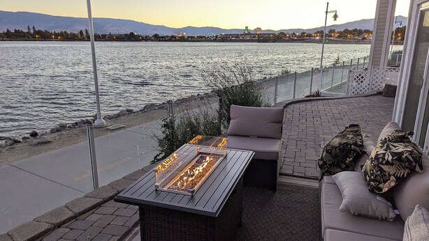 A patio with a fire pit, seating area, and a view of the water. - Luxury Lakefront Escape with Stunning Views at Sparks Marina (Sparks)