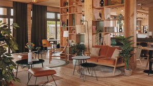 Amplia sala de estar con muebles de madera, estanterías empotradas y vistas al exterior.