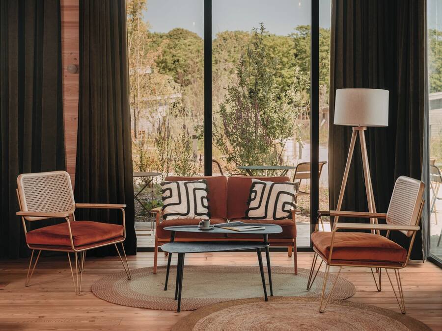A modern living room with a sofa, two armchairs, a coffee table, and a floor lamp.