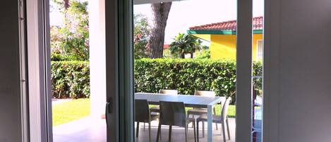 A room with a sliding glass door leading to an outdoor patio with a table and chairs.