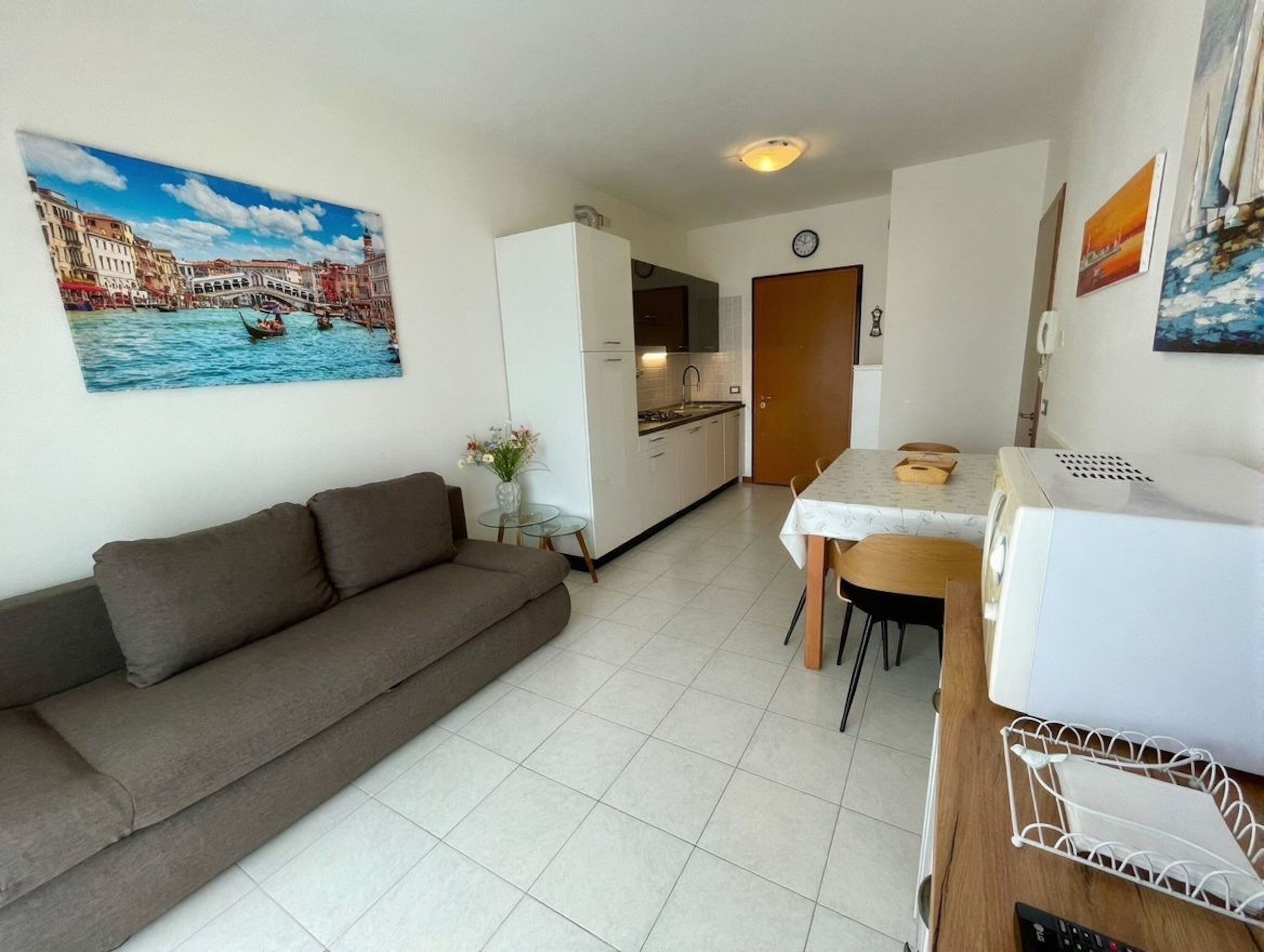 A compact living space with a kitchenette, a dining area, and a sofa.