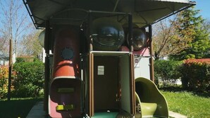 A playground with slides and a covered playhouse structure. - Camping 3 étoiles - Piscine  - eeefba (Verteillac)