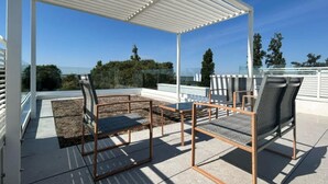 An outdoor patio with a pergola, two chairs, and a table. - Stunning villa with pool and lagoon view (Isola di Albarella)