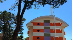 Un bâtiment moderne doté d’un toit incurvé et d’une base blanche.