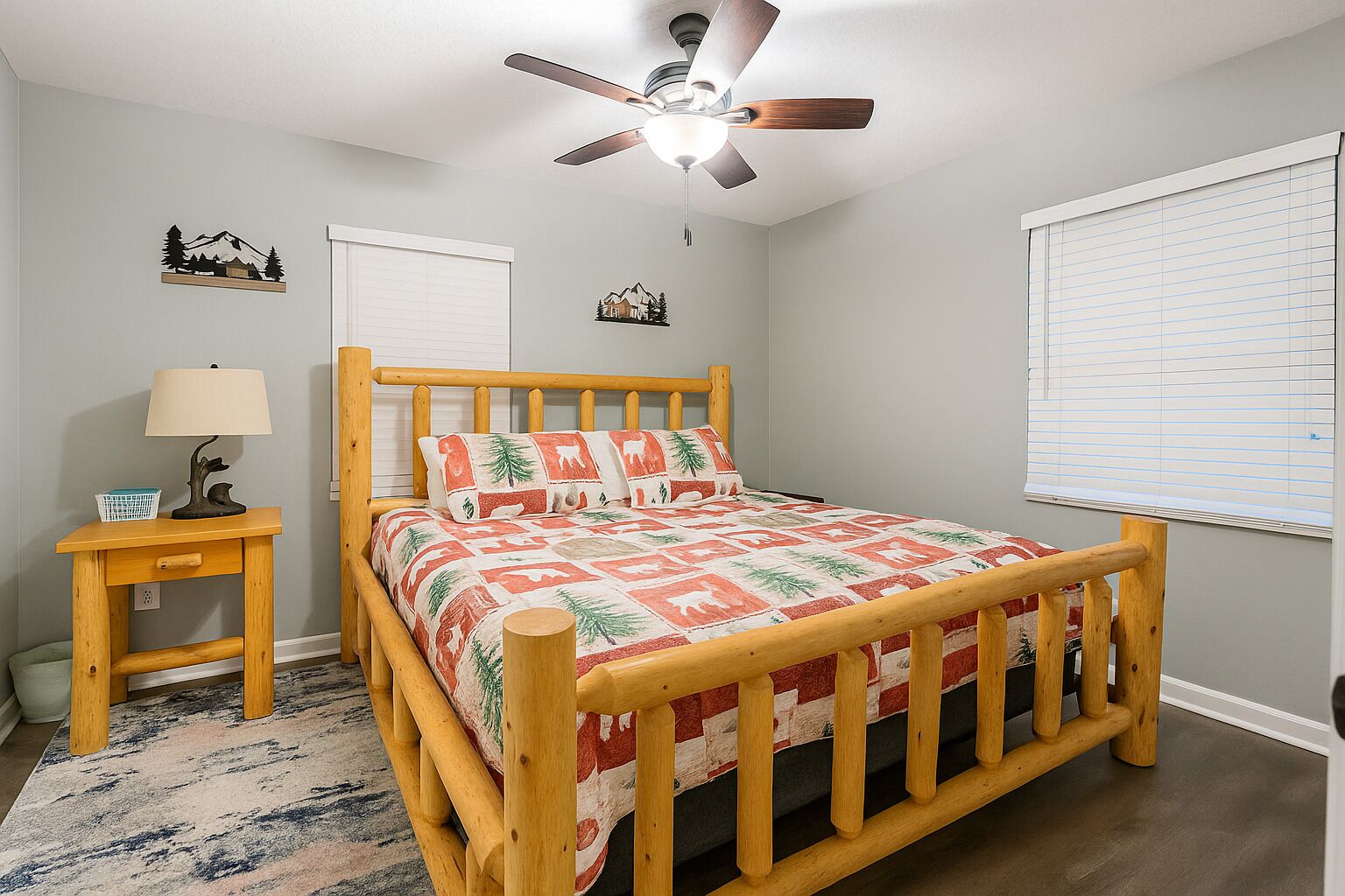 A bedroom with a wooden bed, a nightstand, a ceiling fan, and a window with blinds.