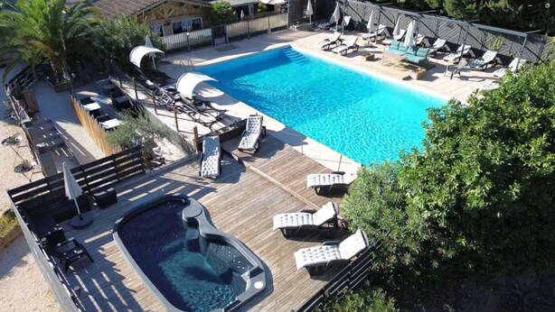 Una piscina con sillas de descanso y un jacuzzi.