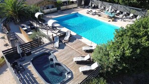 Una piscina con sillas de descanso y un jacuzzi.
