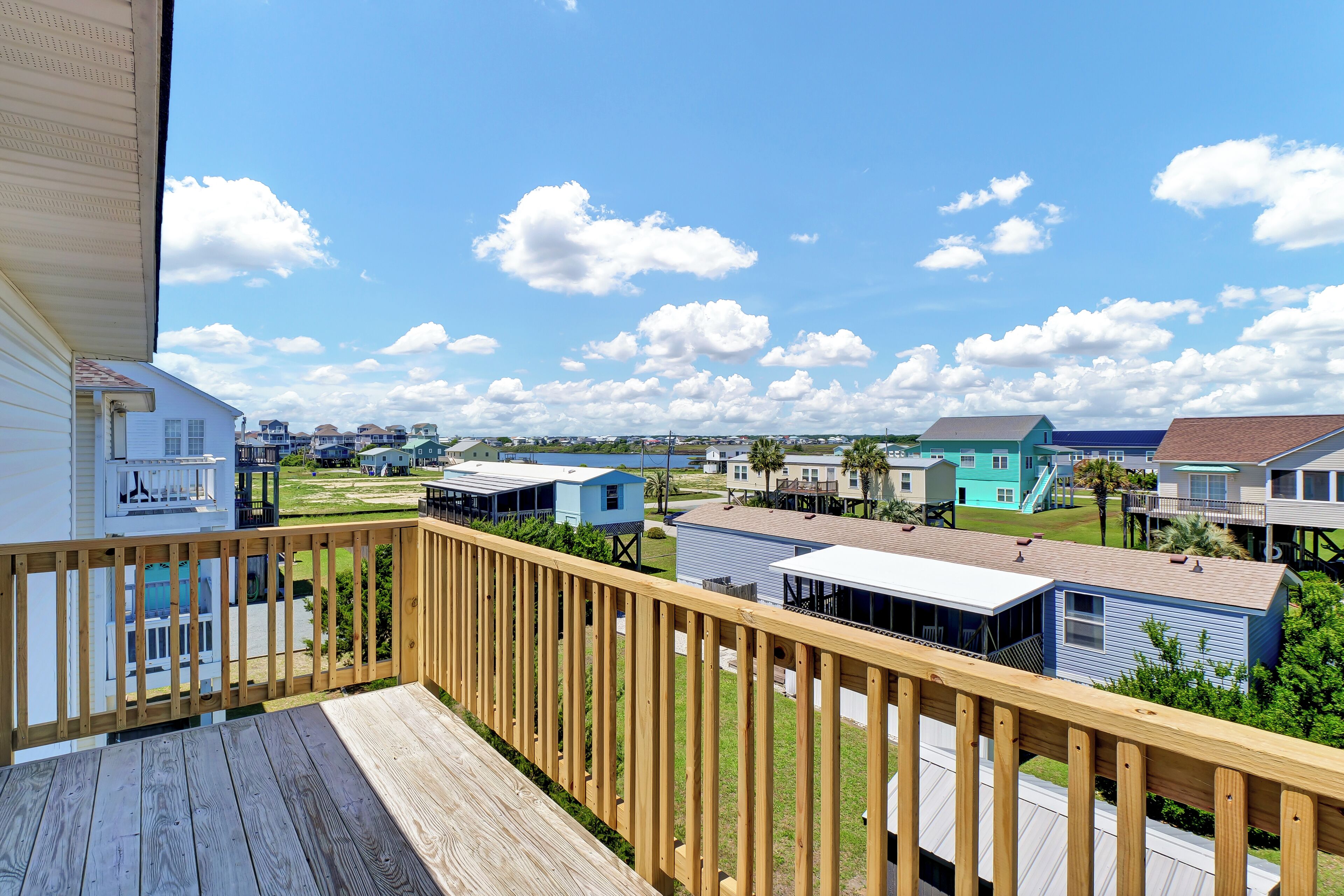 A wooden deck with a view of a row of small, colorful houses.