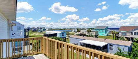 A wooden deck with a view of a row of small, colorful houses.