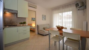 A compact kitchen with a dining area, a sofa, and a television. - Cozy flat ideal for 5 guests (Bibione)