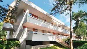 Un immeuble à plusieurs étages doté de balcons, d’un escalier et d’un espace jardin.