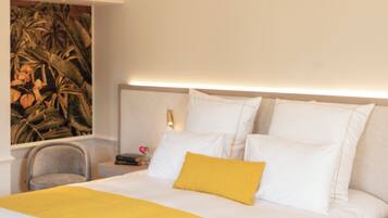 Una habitación de hotel con una cama, una mesita de noche, una silla y un cuadro en la pared.