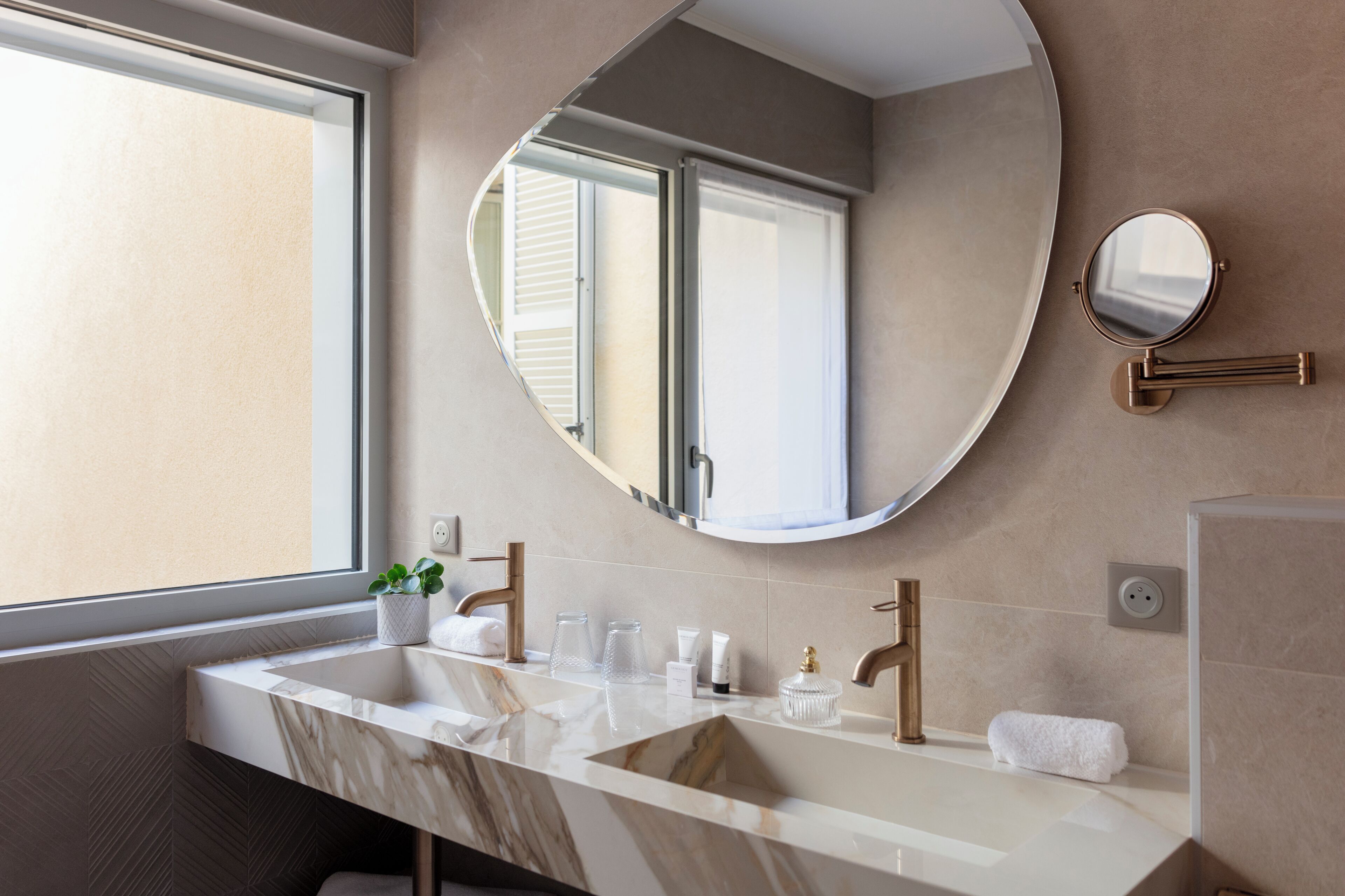 Une salle de bain moderne avec un grand lavabo, un miroir et une fenêtre.