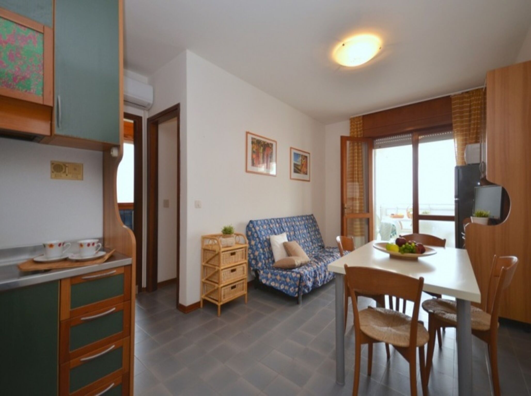 A compact living space with a kitchenette, a dining area, and a sofa.