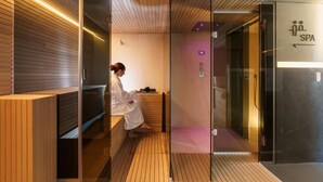 A spa area with a wooden floor, a person in a robe, and a glass door labeled "SPA". - Meo Design Suite & Spa (Catania)