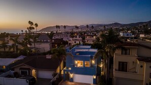 A residential area with houses, palm trees, and a view of the ocean at dusk. - Summer Sunset - Easy Breezy Beach Life in Ventura (Ventura)