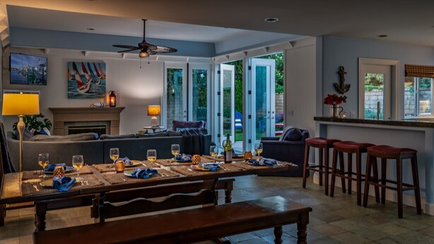 A dining area with a long table set for six, a bench, and a bar area with stools. - Summer Sunset - Easy Breezy Beach Life in Ventura (Ventura)