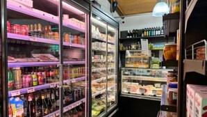A refrigerated display case with various beverages and packaged goods.