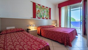 Habitación de hotel con dos camas, un ventanal con vistas y una obra de arte colgada en la pared.