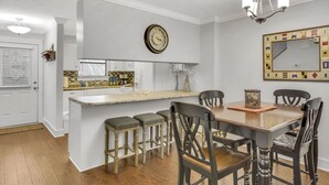 Une cuisine dotée d’un îlot central, de tabourets de bar et d’une table à manger avec des chaises.