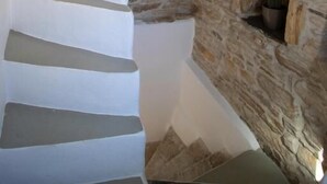 A staircase with white steps leading to a stone wall. - Platsa's House (Naxos)