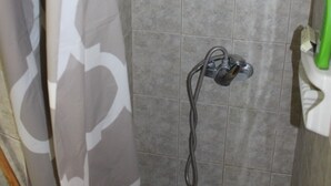 Un espace douche équipé d’un pommeau de douche à main et d’un robinet mural.