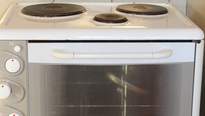 Une cuisinière blanche dotée de quatre brûleurs et d’un panneau de commande avec quatre boutons.