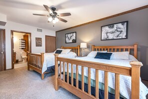 Ein Schlafzimmer mit zwei Holzbetten, einem Deckenventilator und Kunstwerken an den Wänden.