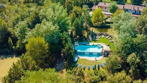 An aerial view of a property with a swimming pool surrounded by lounge chairs, a small building, and dense greenery. - Fonte Di Pierdo - Eleven Bedroom Villa, Sleeps 22 (Castelfranco di sotto)