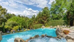 A swimming pool with a hot tub surrounded by rocks, trees, and outdoor seating. - Fonte Di Pierdo - Eleven Bedroom Villa, Sleeps 22 (Castelfranco di sotto)
