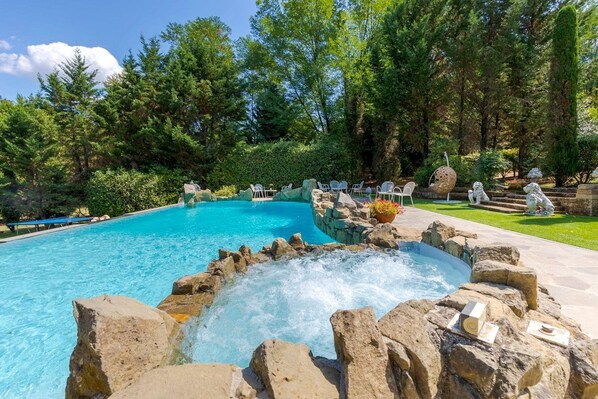 A swimming pool with a hot tub surrounded by rocks and plants. - Fonte Di Pierdo - Eleven Bedroom Villa, Sleeps 22 (Castelfranco di sotto)