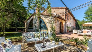 An outdoor patio with a stone archway, white furniture, and a pergola. - Fonte Di Pierdo - Eleven Bedroom Villa, Sleeps 22 (Castelfranco di sotto)