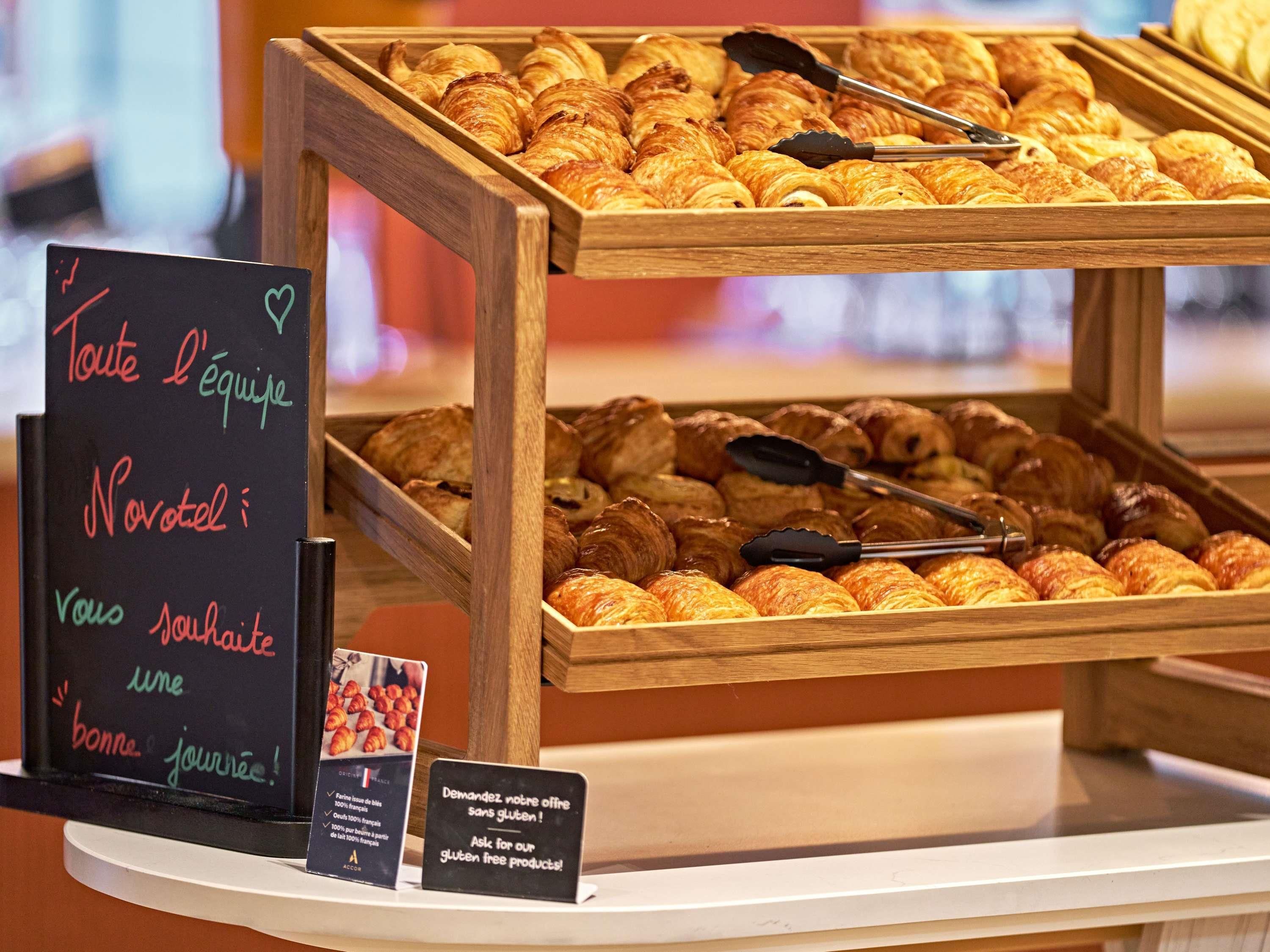 A bakery display with various pastries and a sign offering gluten-free options.