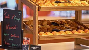 A bakery display with various pastries and a sign offering gluten-free options.