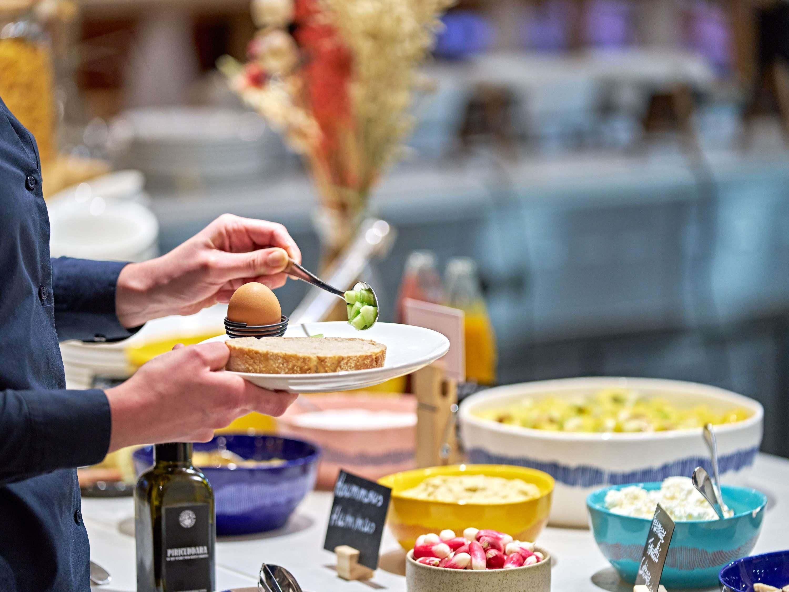 A buffet with various food items, including a bowl of radishes, a bowl of cottage cheese, and a plate with a slice of bread and an egg.