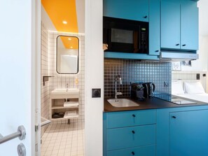 A modern bathroom with a white sink, mirror, and tiled walls. - Aparthotel Adagio Access Rouen Centre Cathédrale (Rouen)