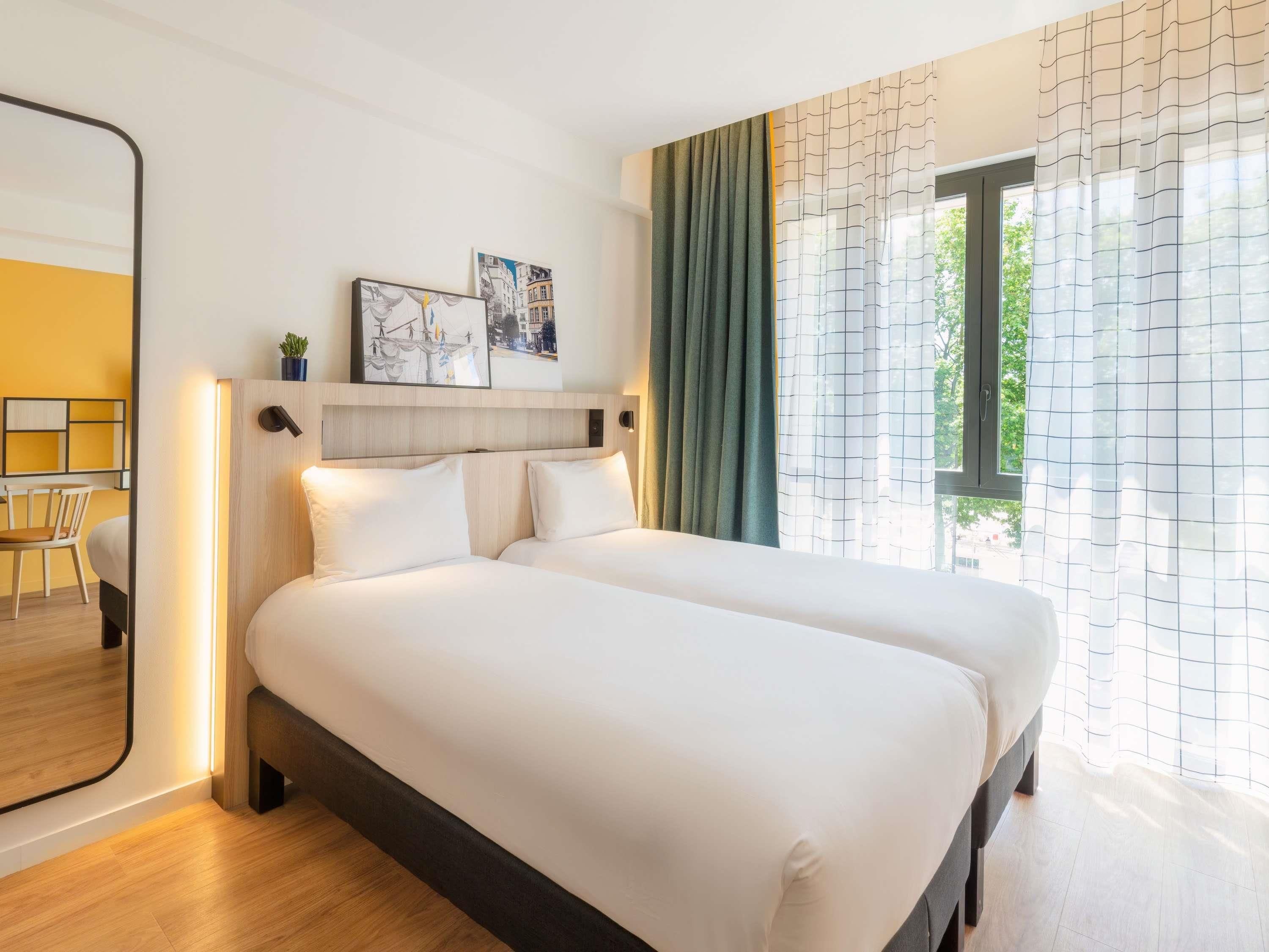 Una habitación de hotel con una cama, un escritorio y una silla.