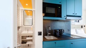 A modern bathroom with a white sink, mirror, and tiled walls. - Aparthotel Adagio Access Rouen Centre Cathédrale (Rouen)