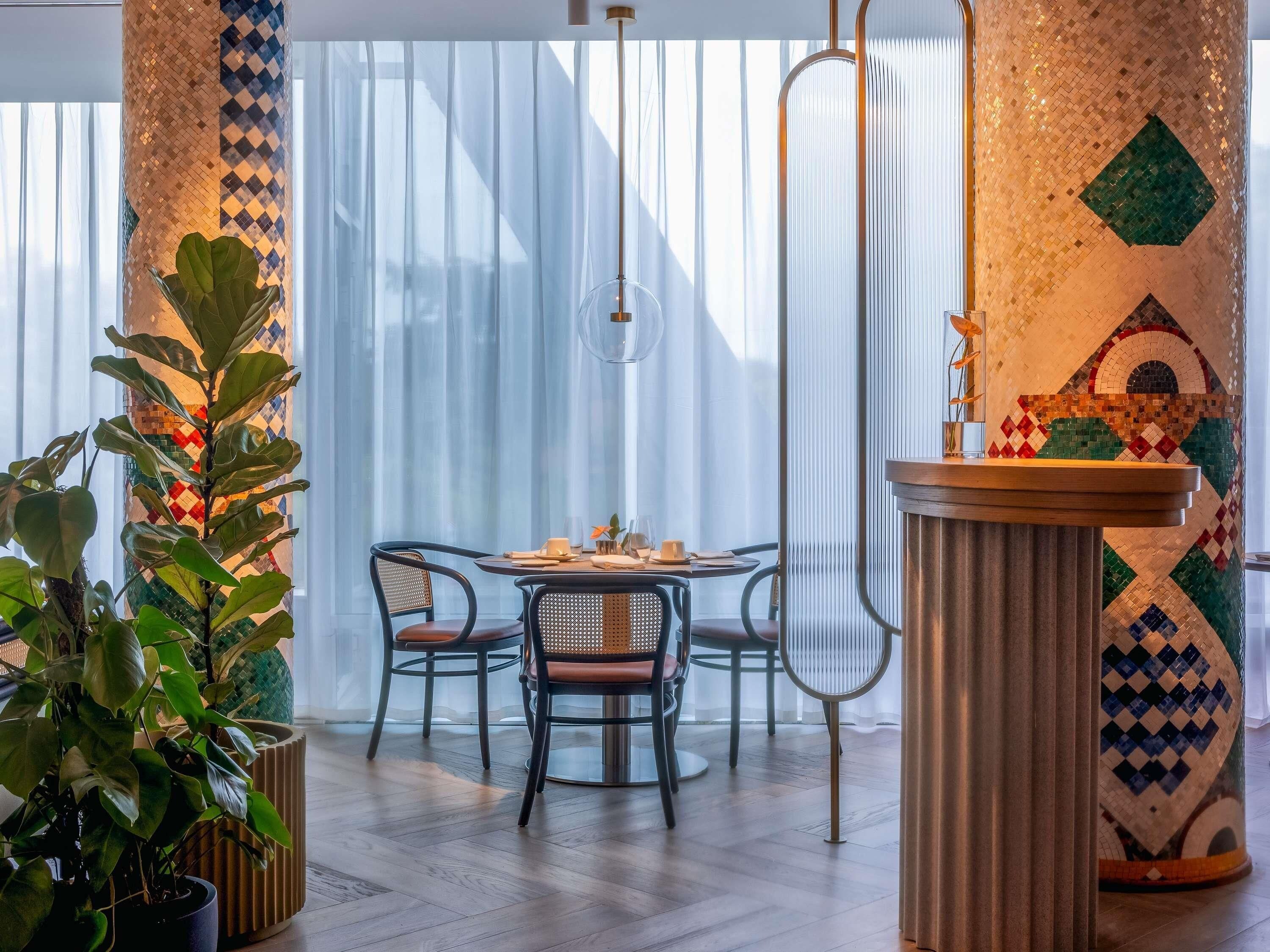 Un'area pranzo con un tavolo rotondo, sedie e una colonna decorativa.