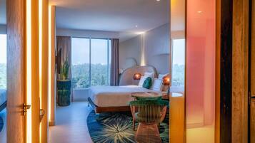 Un dormitorio moderno con una cama grande, lámparas de noche, una mesita y vistas al exterior.