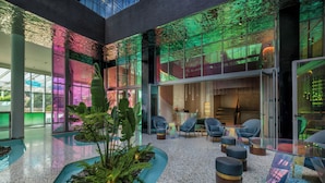 A spacious lobby with a glass ceiling, seating area, and indoor plants. - Gem Forest Hotel Nairobi - MGallery Collection (Nairobi)